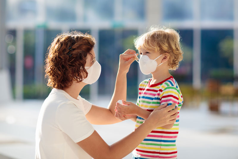 Telehealth-care-changes-with-Mother-and-child-with-face-mask-and-hand-sanitizer